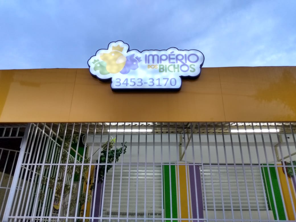 Letreiro iluminado do Império dos Bichos na fachada da loja